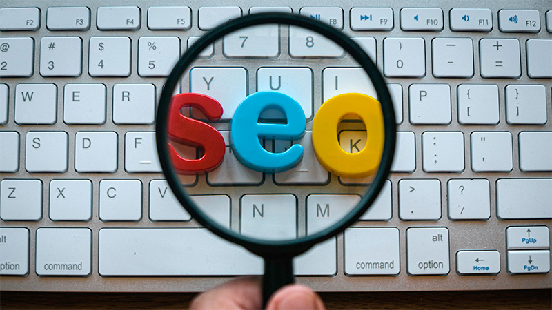 Search Engine Optimization Concept A Hand Holding Magnifying Glass