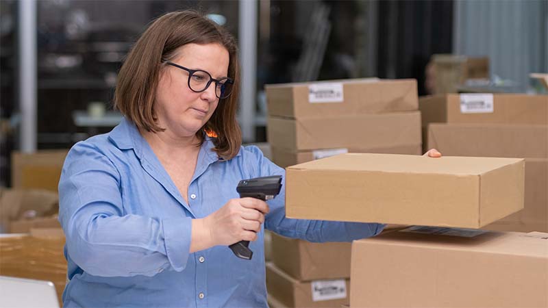 Woman Scanning Barcode To Track Inventory