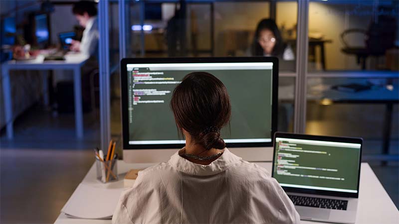 Young Programmer At Workplace In Evening